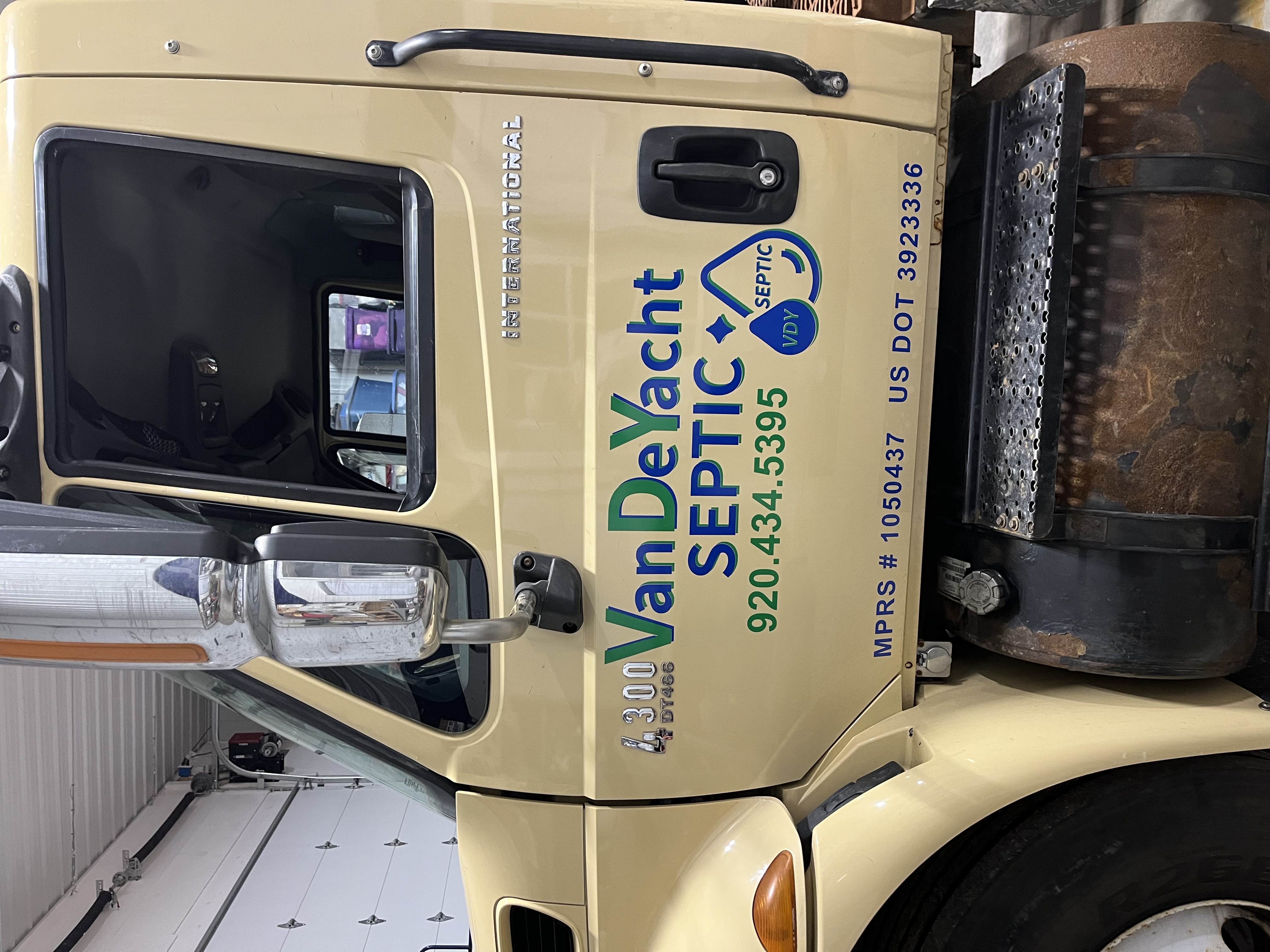 yellow work truck with logo on the side door